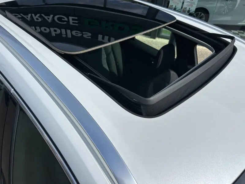 Toit ouvrant panoramique ouvert vu en gros plan sur un Volvo XC60 blanc cristal métallisé.