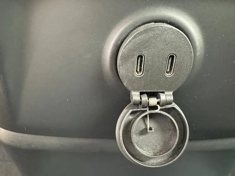 Prise USB-C double noire en gros plan dans le coffre du Volvo XC60 blanc Cristal Métallisé 2024.