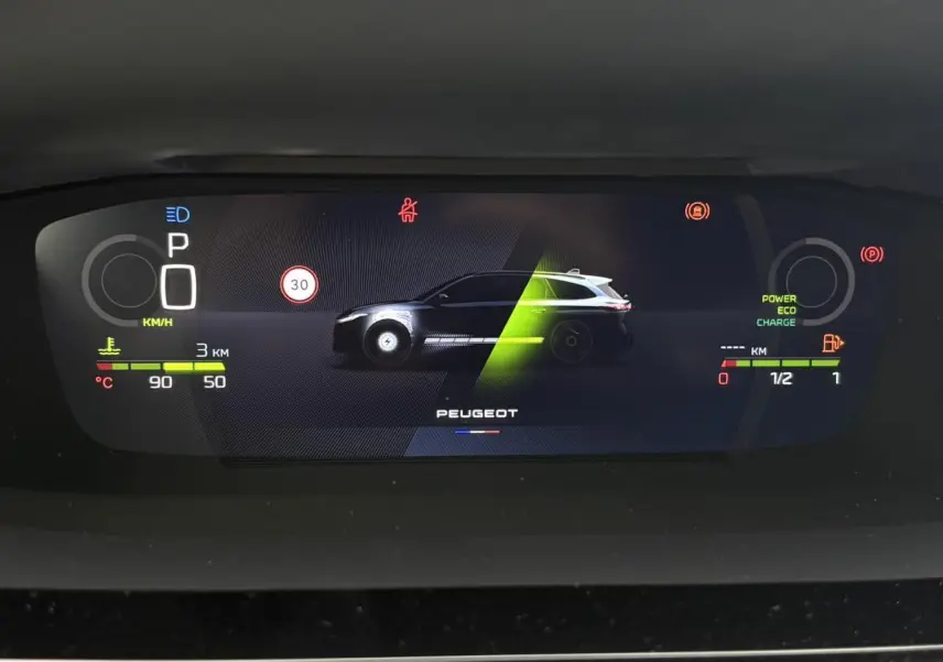 Affichage numérique du combiné de bord Peugeot 308 SW Hybrid, montrant silhouette du véhicule et indicateurs de charge et vitesse.