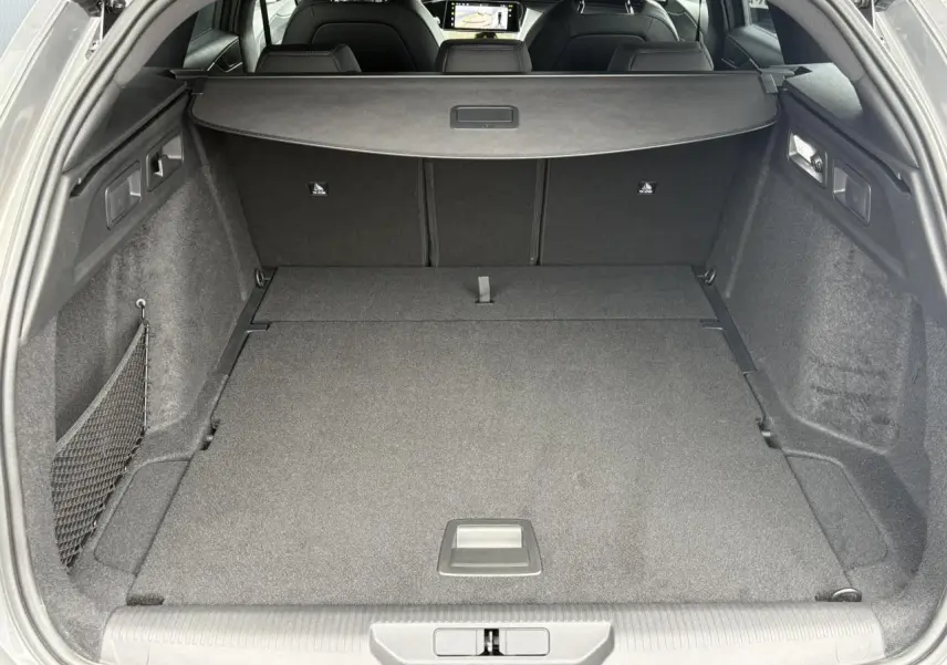 Coffre spacieux de la Peugeot 308 SW gris Sélénium, vue arrière avec plancher modulable et filet latéral.