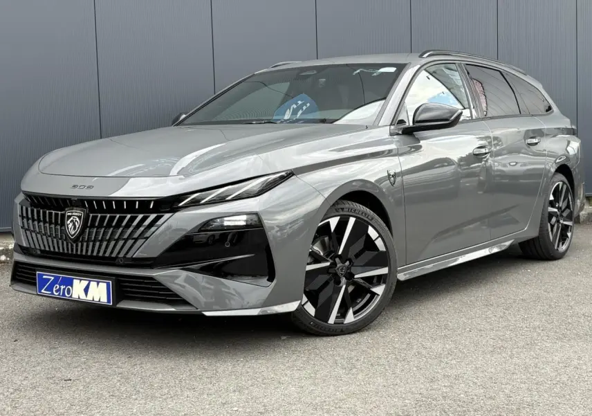 Peugeot 308 SW gris Sélénium vue 3/4 avant droit, avec jantes alliage noires et calandre distinctive noire.