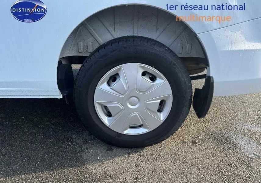 Gros plan sur la roue arrière droite d’un Ford Transit Custom blanc avec enjoliveur et garde-boue noir.