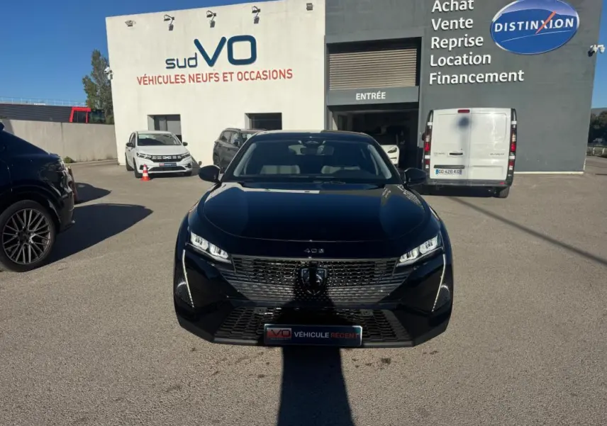 PEUGEOT 408 Hybrid 145 e-DCS6 Allure noir vu de face, avec calandre distinctive et phares LED allumés.