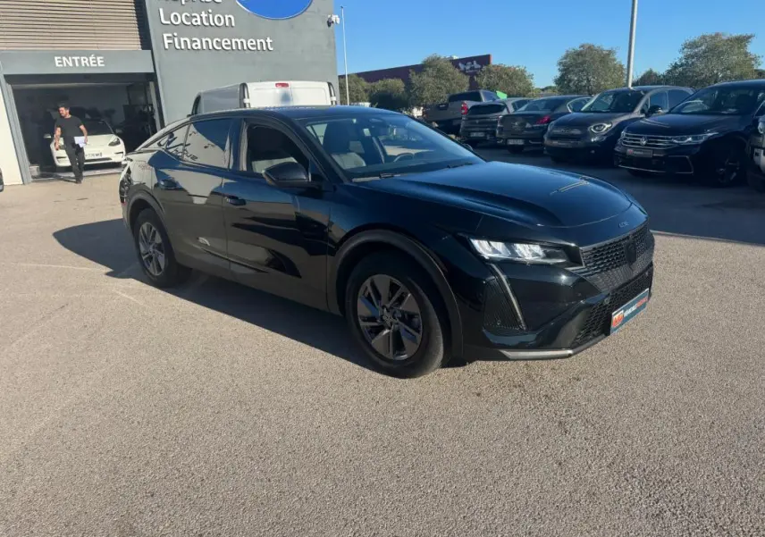 Peugeot 408 Hybrid 145 e-DCS6 Allure noir vue en 3/4 avant droit sur un parking extérieur ensoleillé.