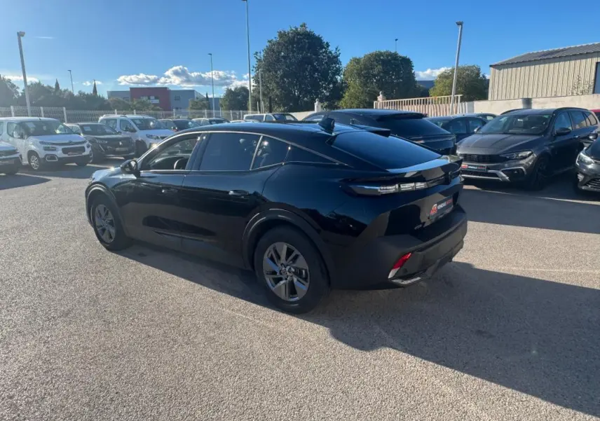 Peugeot 408 Hybrid 145 e-DCS6 Allure noire vue 3/4 arrière droit, avec feux arrière LED et toit noir brillant.