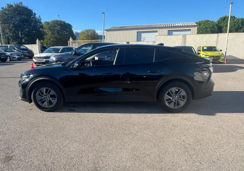 Peugeot 408 Hybrid 145 e-DCS6 Allure noire vue de profil côté gauche, avec lignes fluides et vitres teintées.
