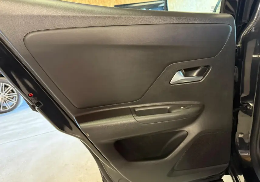 Vue intérieure de la porte arrière droite noire de l’Opel Mokka 2025, avec poignée et haut-parleur intégrés.