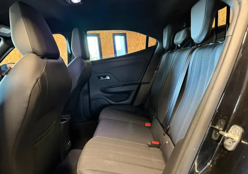 Vue intérieure arrière côté droit de l’Opel Mokka 2025, montrant la banquette mixte tissu noir et gris avec appuie-têtes réglables.
