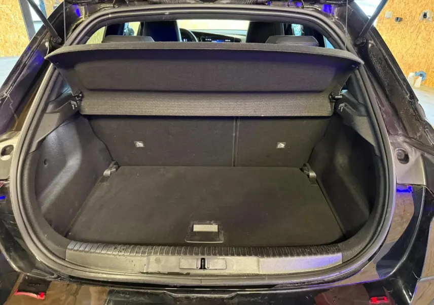 Coffre ouvert vu de l'arrière d'un Opel Mokka noir, montrant l'espace de chargement avec cache-bagages déployé.