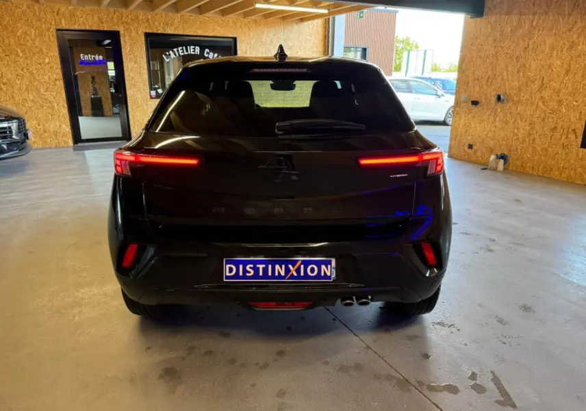 Vue arrière d’un Opel Mokka noir 2025 avec feux LED allumés et double sortie d’échappement visible en intérieur.