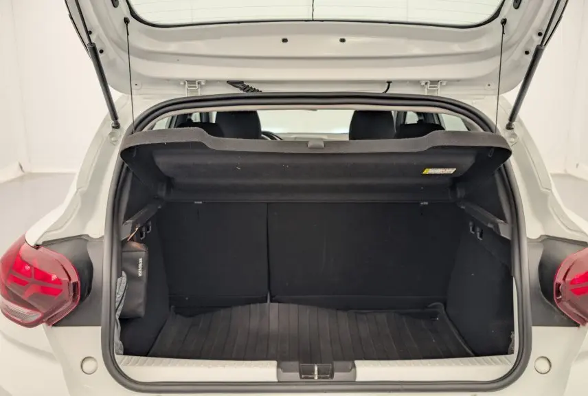 Coffre ouvert vu de l'arrière d'une Dacia Sandero blanc glacier 2022 avec feux arrière à signature lumineuse en Y.