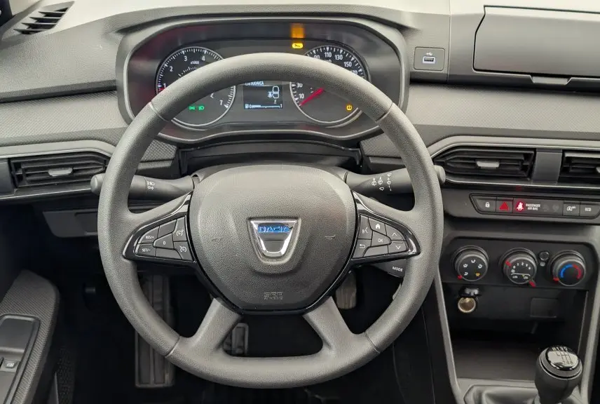 Vue frontale du tableau de bord de la Dacia Sandero 2022, volant multifonction et commandes climatiques visibles.