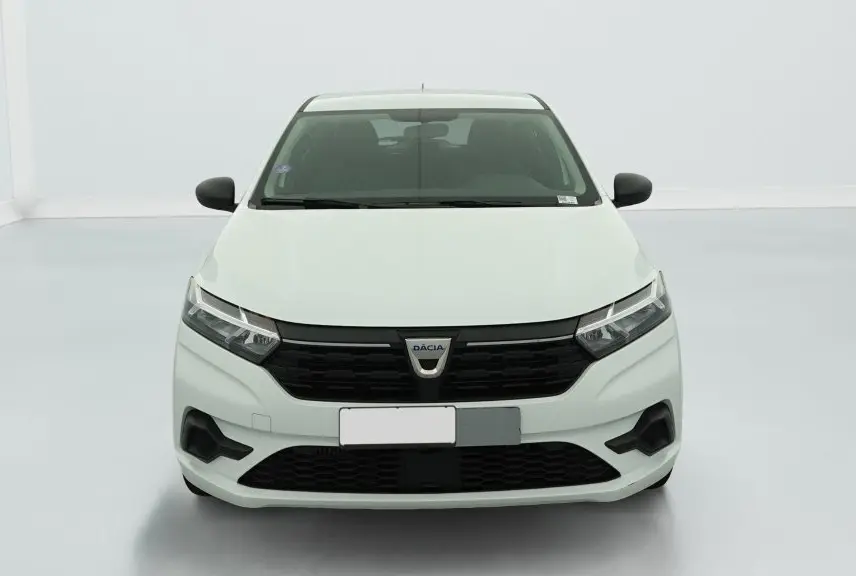 Vue frontale d'une Dacia Sandero blanche avec calandre noire et signature lumineuse en Y à LED visible.