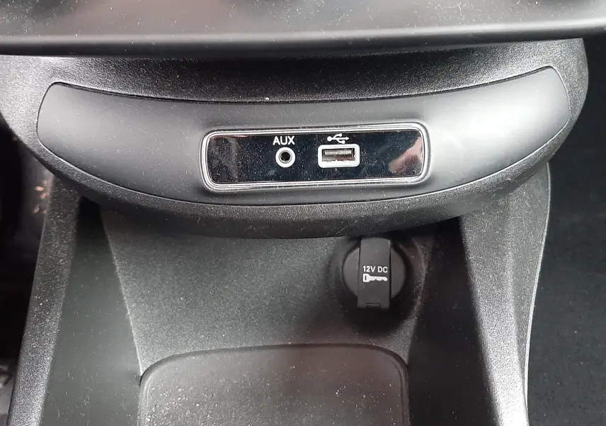 Vue rapprochée de la console centrale noire du Fiat 500X 2016 montrant prises USB, AUX et allume-cigare 12V.