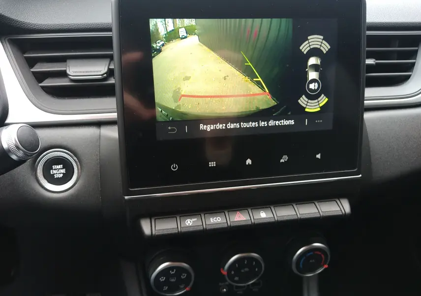Vue rapprochée de l’écran central du tableau de bord du Renault Captur noir, affichant la caméra de recul et les commandes climatisation.