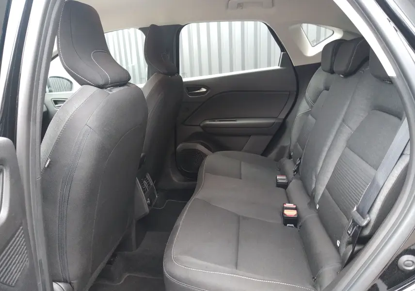 Vue intérieure côté droit sur la banquette arrière noire en tissu du Renault Captur 2021, avec appuie-têtes et ceintures visibles.