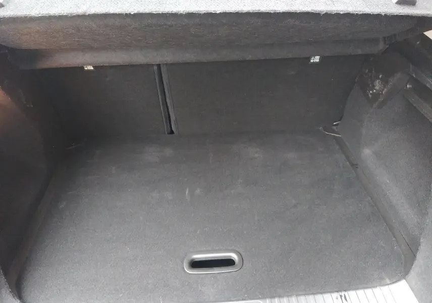 Coffre vide en tissu noir du Renault Captur 1.0 TCE 90ch Business, vue intérieure depuis l'arrière du véhicule.