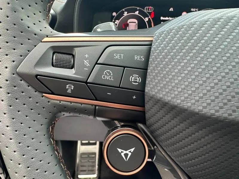 Gros plan sur les commandes multifonctions du volant cuir perforé noir du CUPRA Formentor 2.0 TDI 150ch V DSG7, avec insert cuivre.