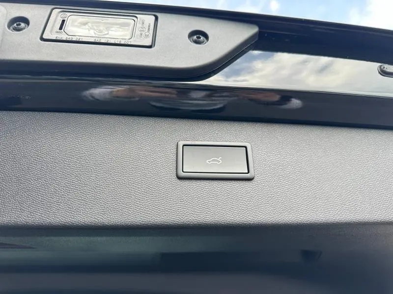 Bouton d'ouverture électrique du coffre sur la partie intérieure du hayon noir métallisé d'un CUPRA Formentor 2025.