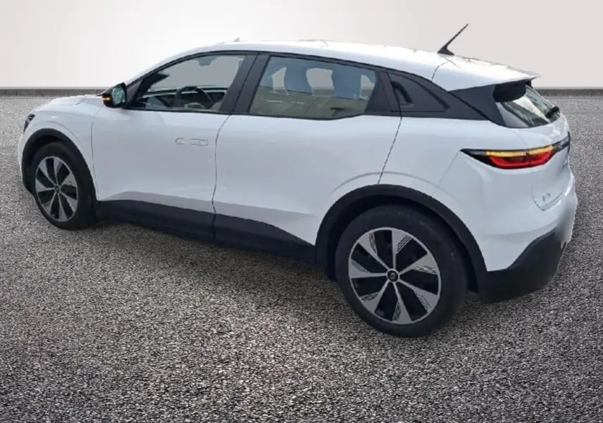 Vue 3/4 arrière droite d'une Renault Mégane électrique blanche avec toit noir et jantes stylisées.