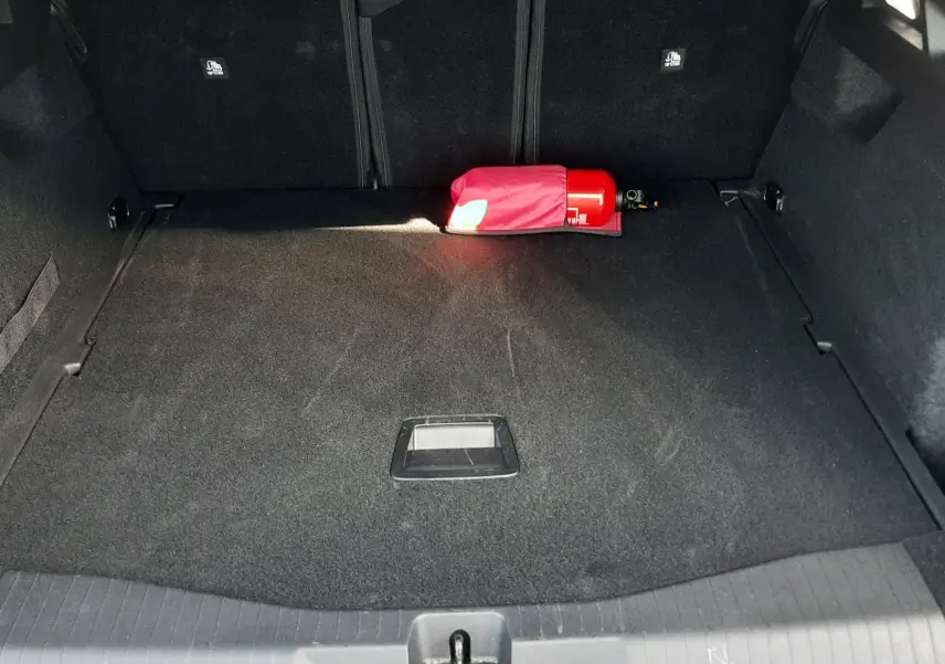 Coffre ouvert du Citroën C5 Aircross hybride gris platinium, montrant un extincteur rouge posé à l’arrière.