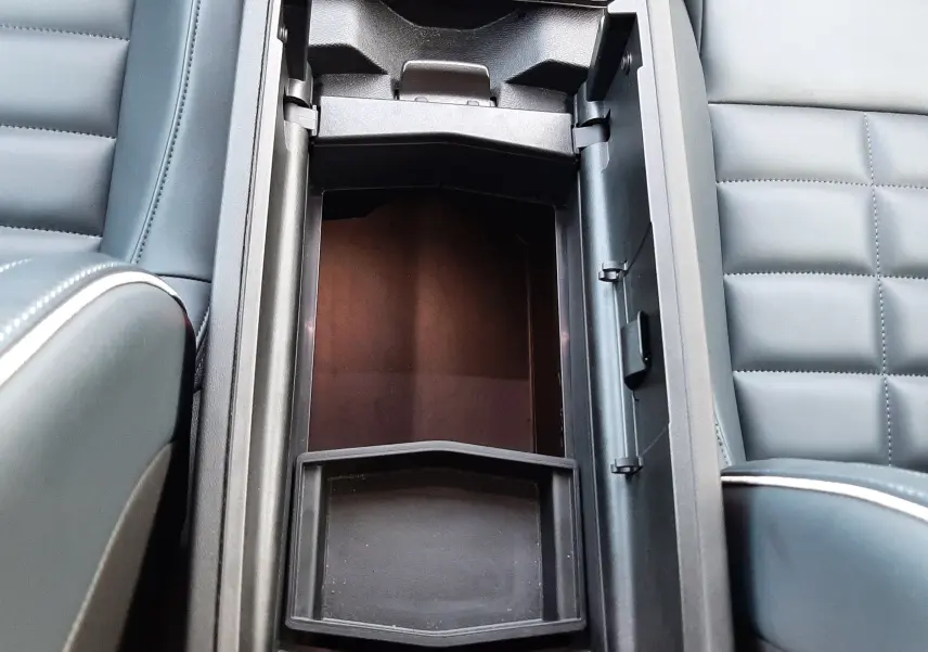 Vue plongeante sur le rangement central ouvert entre les sièges gris platinium du Citroën C5 Aircross hybride 2026.