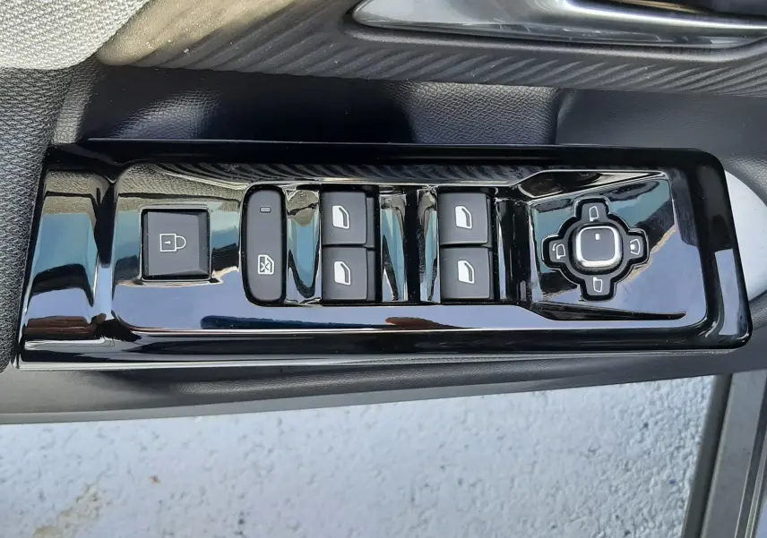 Gros plan sur la commande des vitres et rétroviseurs côté gauche d’un Citroën C5 Aircross gris platinium 2026.