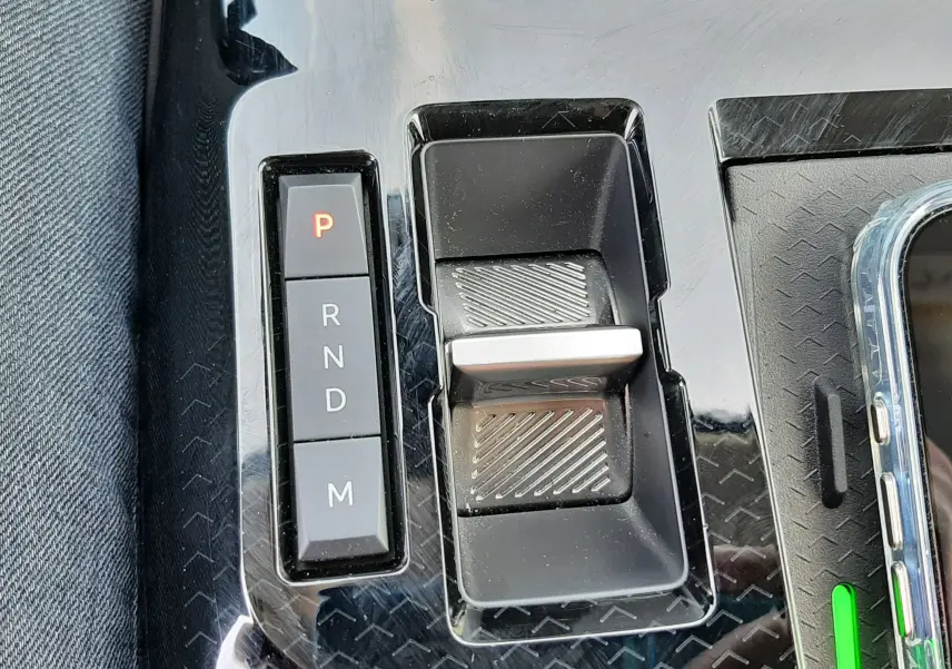 Gros plan sur la console centrale noire brillante du Citroën C5 Aircross hybride avec levier de vitesses électronique et boutons P, R, N, D, M.