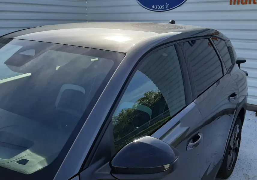Vue 3/4 avant droit du Citroën C5 Aircross hybride gris platinium avec rétroviseur et vitres teintées visibles.
