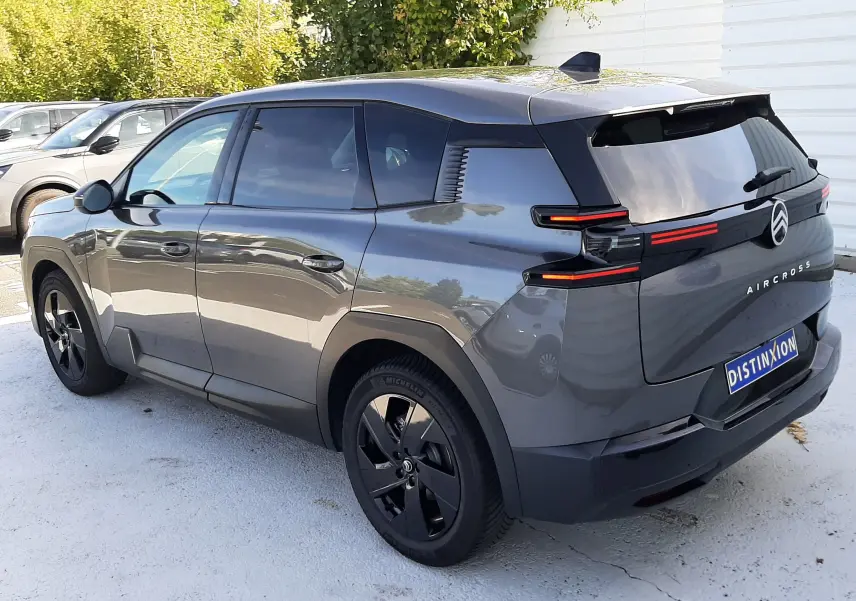 Vue 3/4 arrière droite d'un Citroën C5 Aircross Hybride gris platinium avec feux arrière LED et jantes noires.