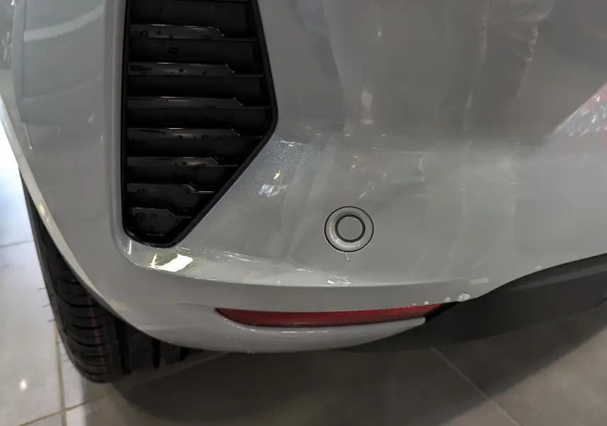 Détail du pare-chocs arrière gris Rafale de la Renault Clio V avec capteur de recul et feu réfléchissant.