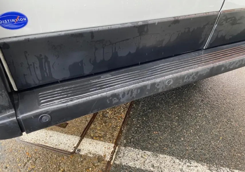Gros plan sur la partie basse côté droit du fourgon blanc Opel Movano 2023 avec marchepied et porte latérale coulissante.