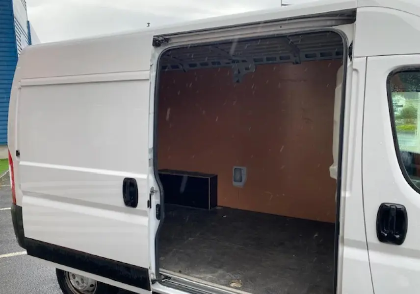 Vue latérale droite d'un Opel Movano Fourgon blanc 2023 avec porte coulissante ouverte montrant l'intérieur vide.