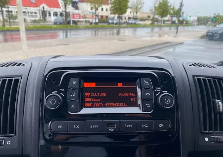 Tableau de bord du fourgon Opel Movano 2023 avec radio numérique allumée, vue frontale rapprochée.