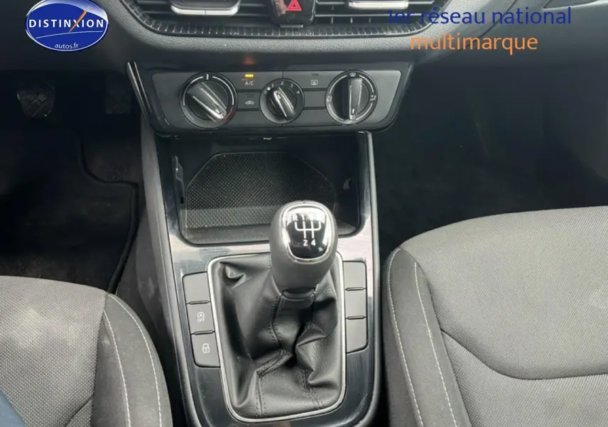 Vue rapprochée du levier de vitesses manuel noir et console centrale de la Skoda Fabia blanche, avec sièges gris visibles.