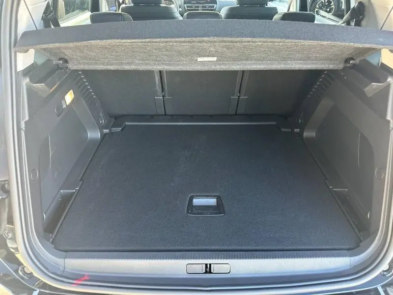 Coffre ouvert vu de l'arrière d'un Citroën C5 Aircross 2025 noir Perla Nera, montrant un espace de chargement spacieux et propre.