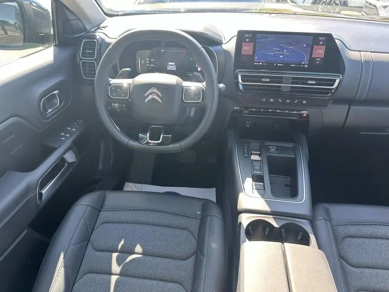 Vue intérieure avant du Citroën C5 Aircross 2025 noir Perla Nera, avec tableau de bord numérique et écran tactile central.