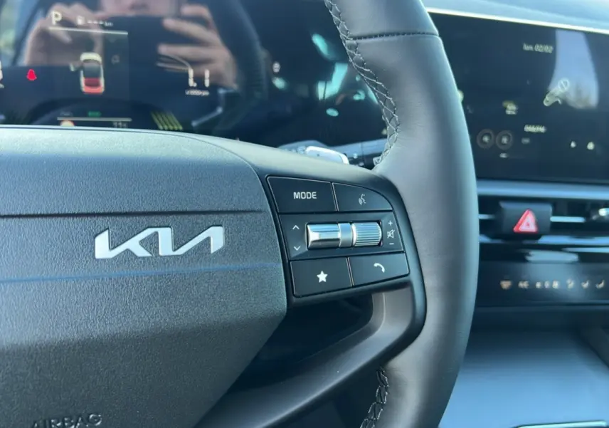 Gros plan sur le volant cuir multifonctions du Kia Sportage 2026, avec logo KIA et commandes intégrées.