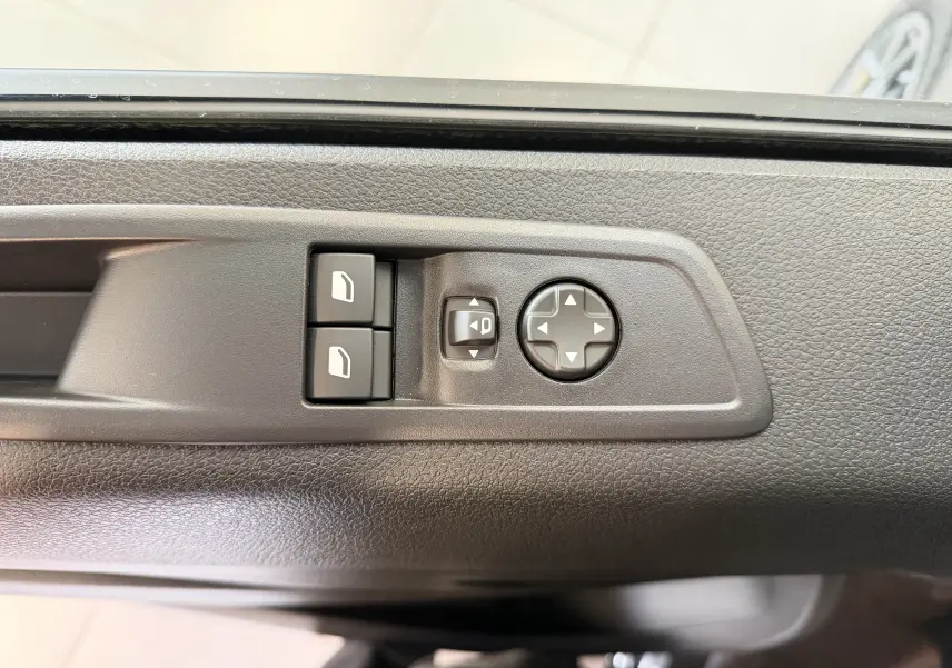 Détail des commandes de réglage des rétroviseurs sur la porte côté conducteur d'un Citroën Jumpy gris titane.
