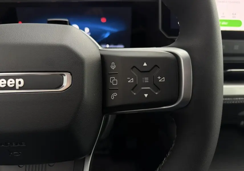 Gros plan sur la partie droite du volant noir du Jeep Compass 2026 avec commandes multifonctions et logo Jeep visible.