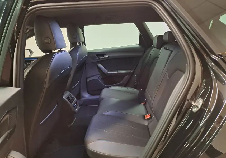 Vue intérieure côté gauche des sièges arrière en cuir noir du CUPRA LEON ST 1.5 eTSI 150 DSG7, ambiance sobre et moderne.