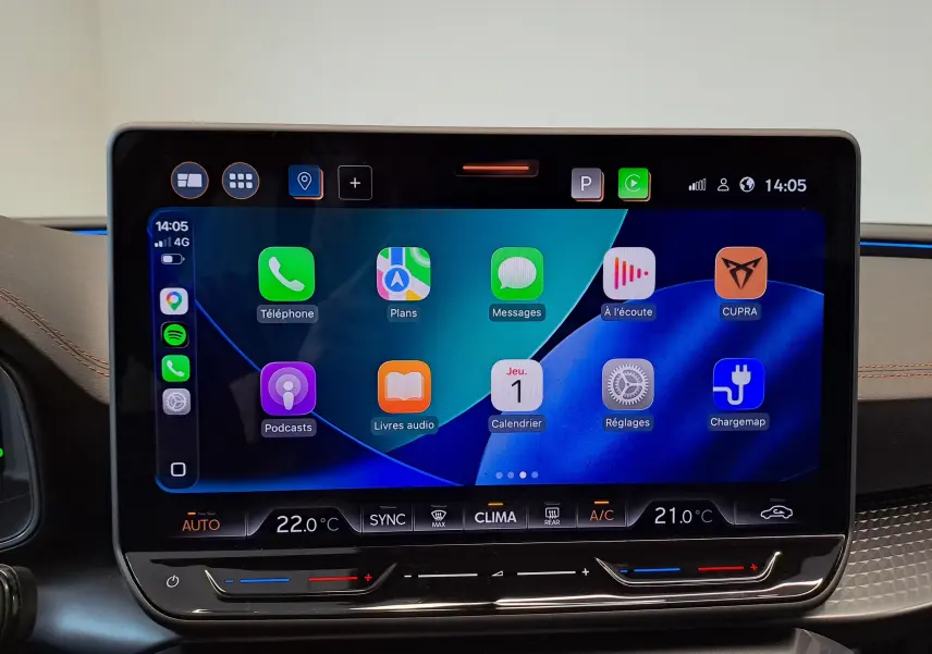 Écran tactile central du tableau de bord du CUPRA LEON ST 2025, affichant Apple CarPlay et commandes climatisation.