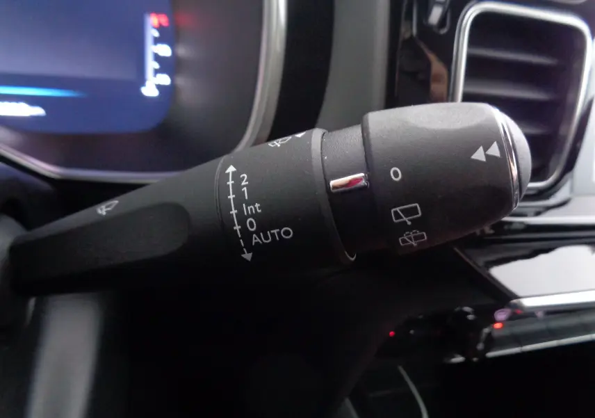 Gros plan sur la commande des essuie-glaces du Citroën C5 Aircross gris Artense, avec tableau de bord et aérateurs en arrière-plan.