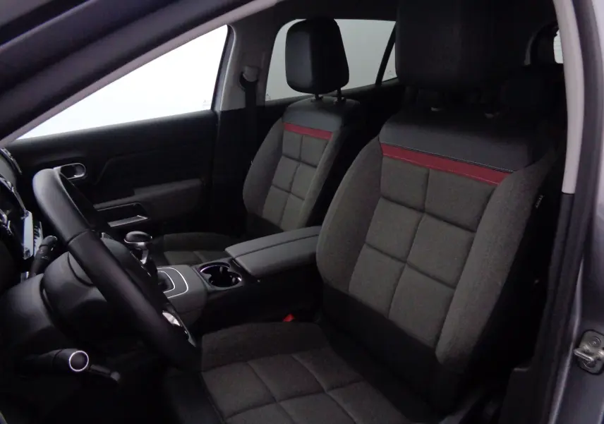 Vue intérieure côté conducteur du Citroën C5 Aircross 2021, sièges gris avec surpiqûres rouges et volant noir.