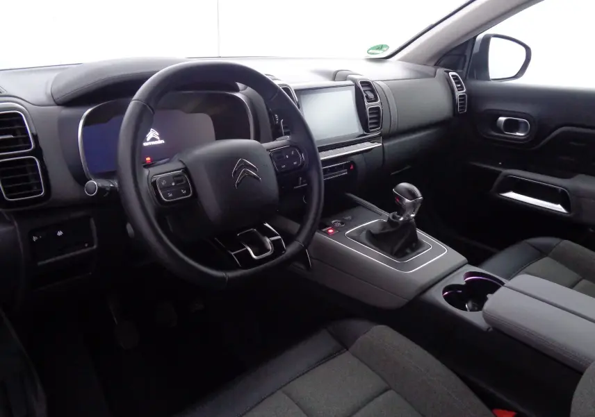 Intérieur du Citroën C5 Aircross 2021 côté conducteur, avec tableau de bord moderne et levier de vitesse manuel.