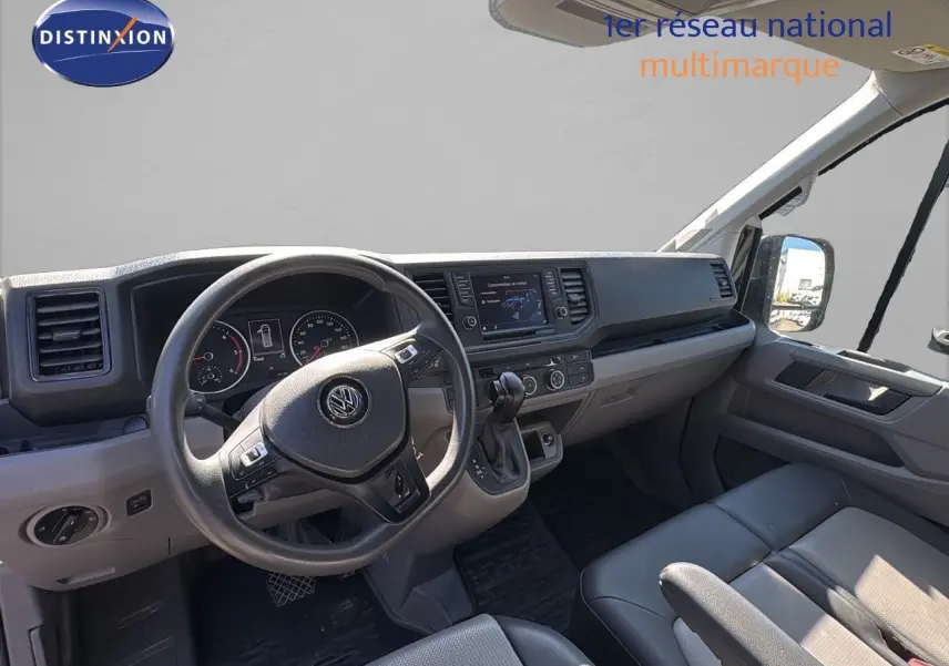 Vue intérieure côté conducteur du Volkswagen Crafter Fourgon 2020 avec tableau de bord moderne et sièges gris.