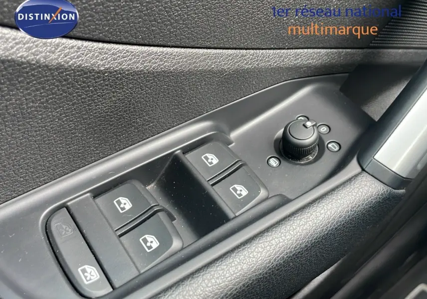 Gros plan sur les commandes des vitres électriques et réglages des rétroviseurs côté conducteur d'un Audi Q2 noir Mito Metal.