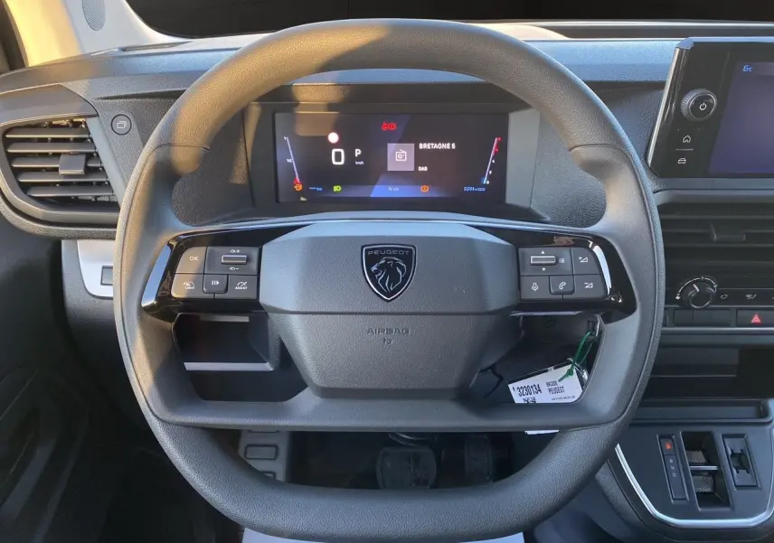 Vue rapprochée du volant noir du Peugeot Expert Cabine Approfondie 2025 avec tableau de bord numérique et écran tactile.