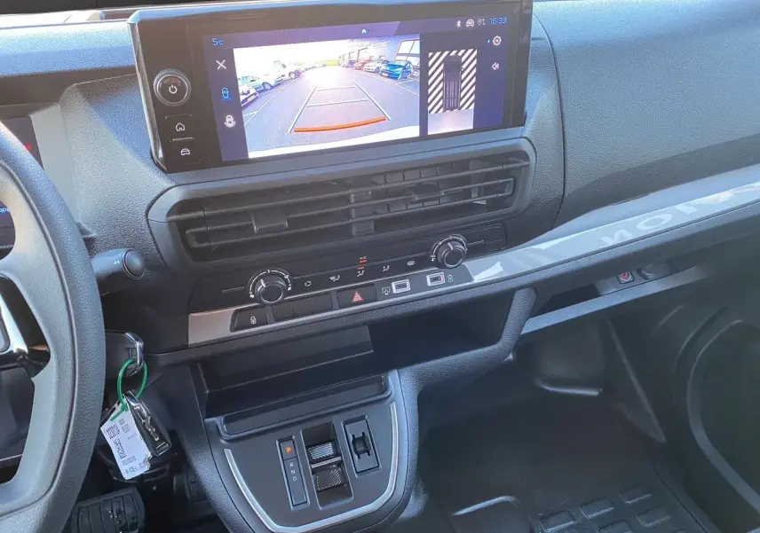 Vue intérieure du tableau de bord du Peugeot Expert cabine approfondie 2025, avec écran tactile et commandes centrales.