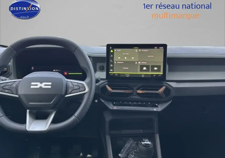 Vue intérieure du tableau de bord et volant du Dacia Bigster 2025, avec écran tactile et détails cuivre sur les aérateurs.